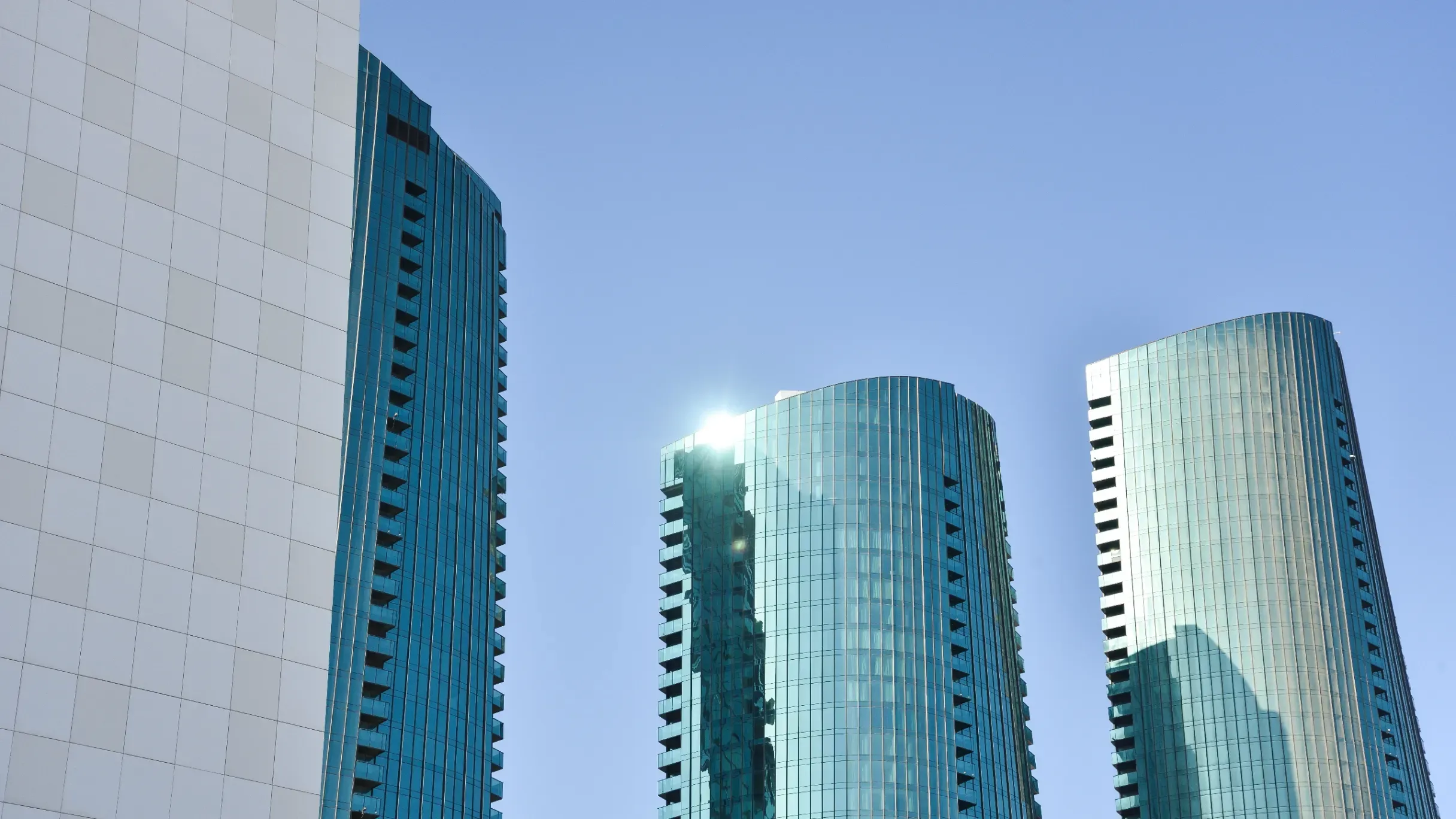 Modern skyscrapers with extensive glass facades reflecting sunlight in the vibrant urban landscape of Bahrain Harbour, Manama.