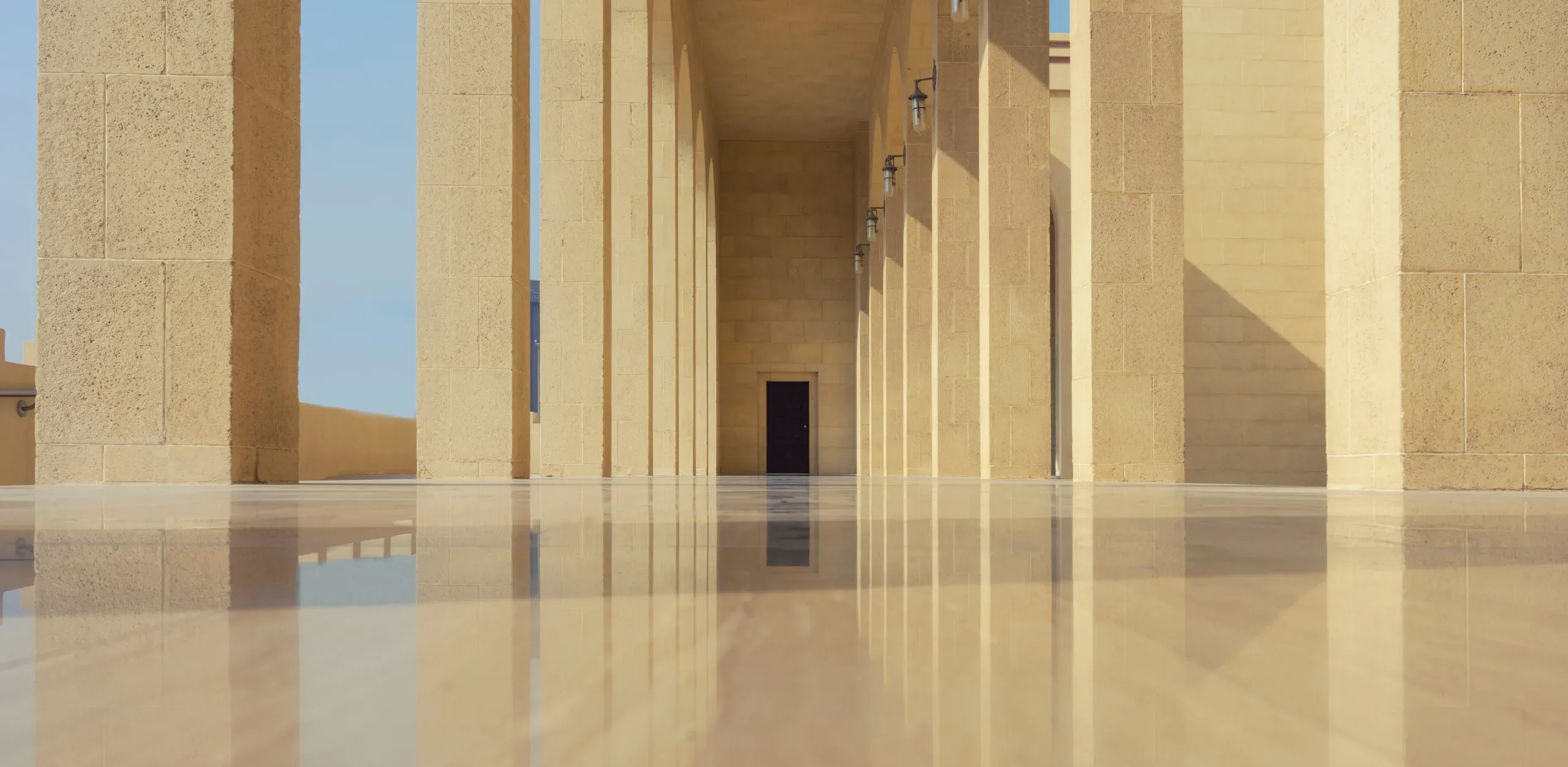 Al-Fateh Grand Mosque entrance colonnade in Manama, showing exquisite Islamic architecture and polished Italian marble floors.