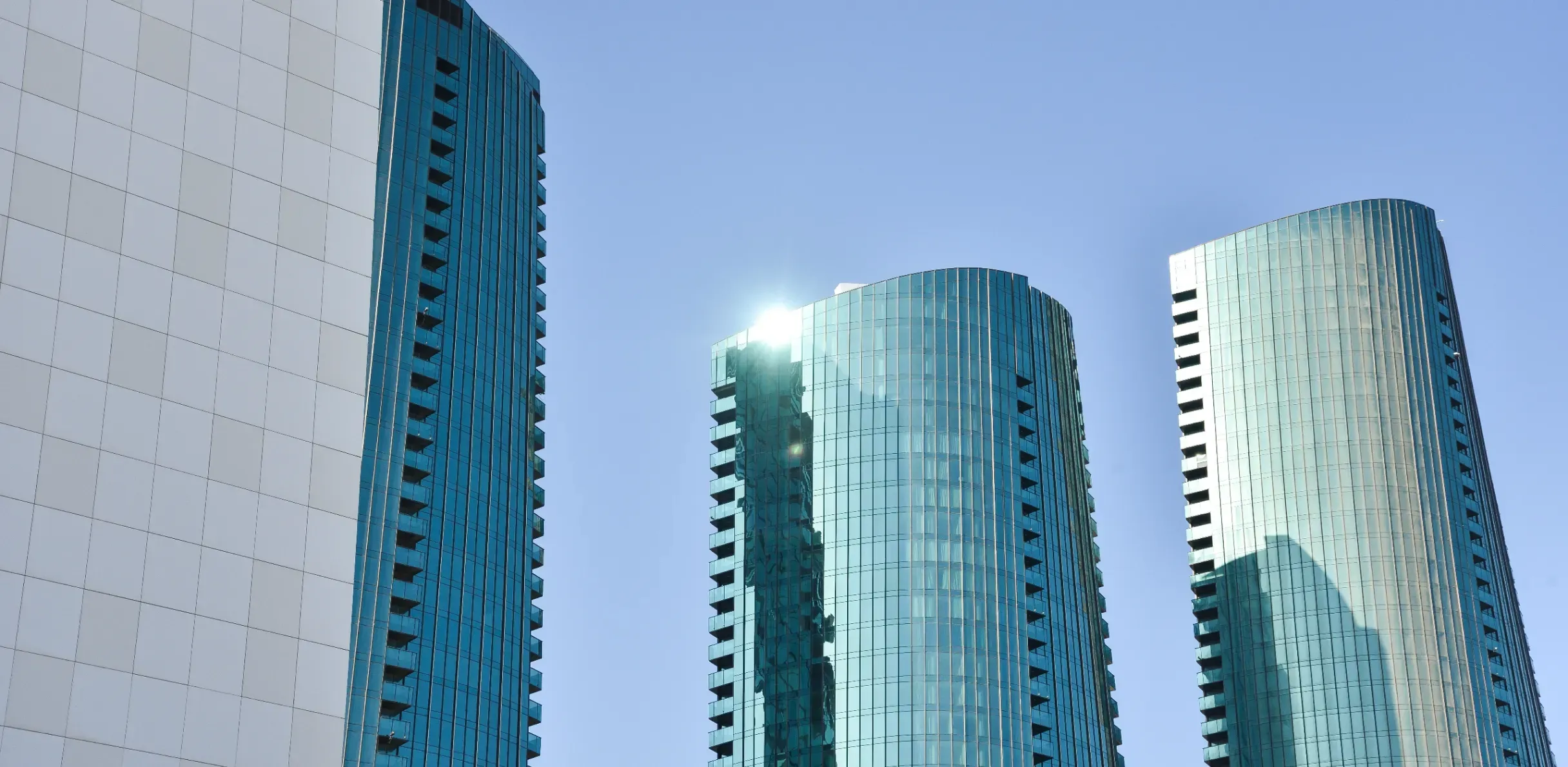 Modern skyscrapers with extensive glass facades reflecting sunlight in the vibrant urban landscape of Bahrain Harbour, Manama.